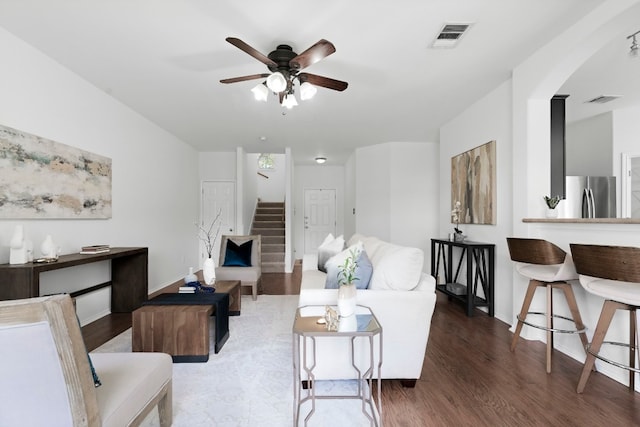 living room with ceiling fan and dark hardwood / wood-style flooring