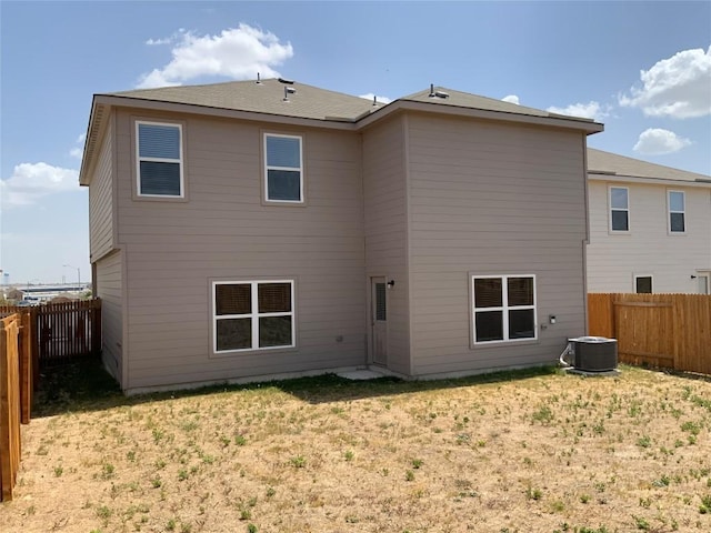 back of house featuring a yard and central air condition unit