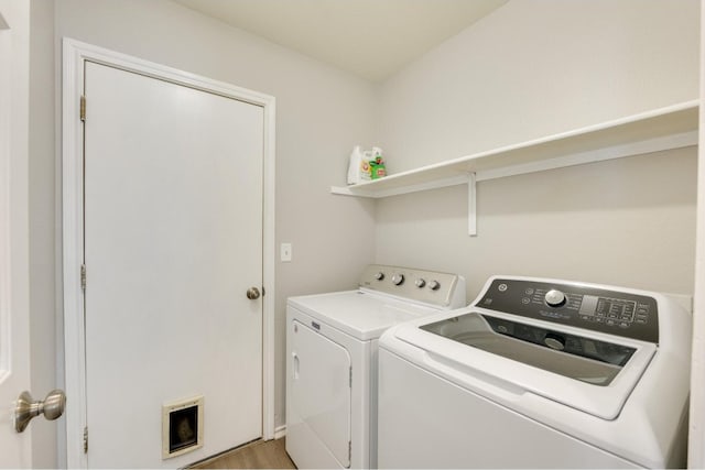 laundry room featuring washer and clothes dryer and light wood-type flooring