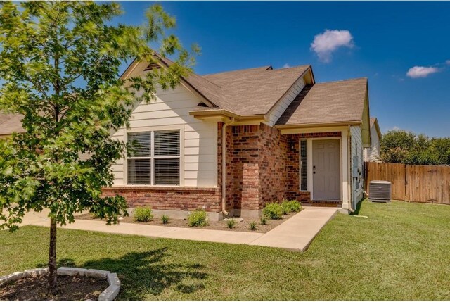 view of front of property with a front lawn and cooling unit