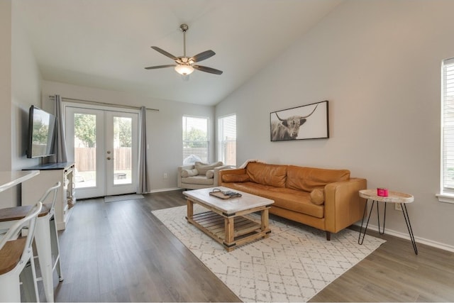 living room with hardwood / wood-style floors, high vaulted ceiling, french doors, and ceiling fan