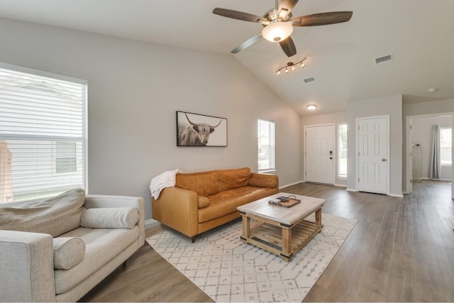 living room with ceiling fan, vaulted ceiling, and wood-type flooring