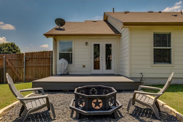 rear view of property featuring an outdoor fire pit and french doors