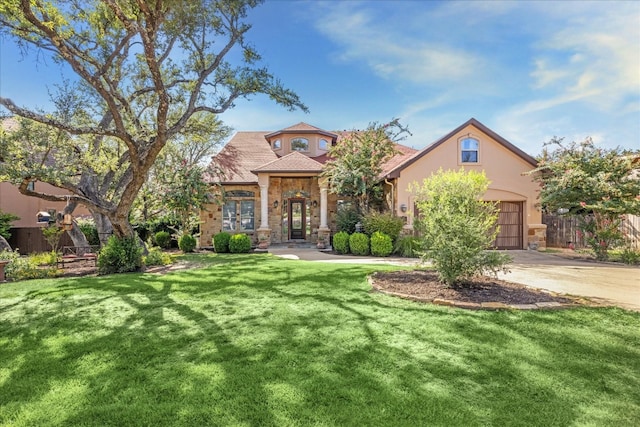 mediterranean / spanish house with a garage and a front lawn