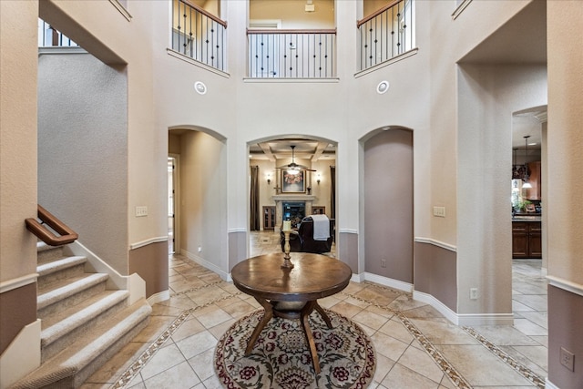 tiled foyer with a towering ceiling