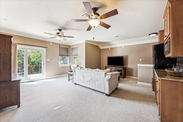 carpeted living room with ceiling fan and crown molding