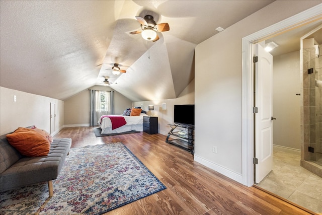 interior space with ceiling fan, vaulted ceiling, a textured ceiling, and wood-type flooring