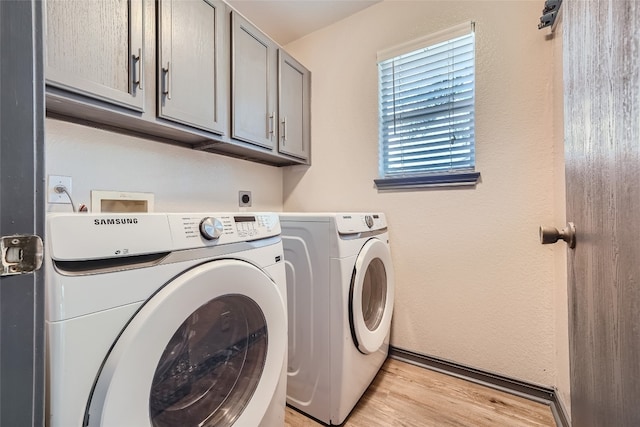 washroom featuring independent washer and dryer, light hardwood / wood-style floors, and cabinets