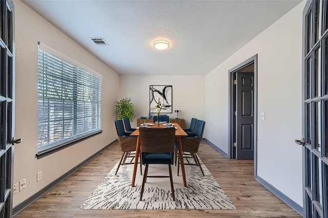 dining space featuring french doors and hardwood / wood-style floors