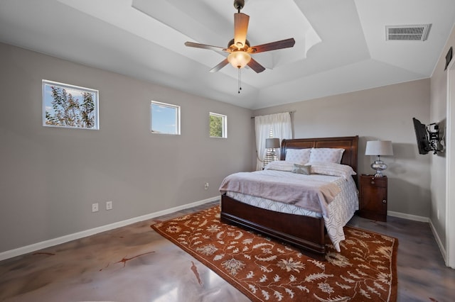 bedroom featuring ceiling fan, a raised ceiling, and concrete flooring