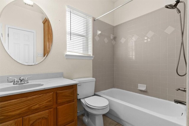 full bathroom featuring tile patterned floors, toilet, tiled shower / bath, and vanity