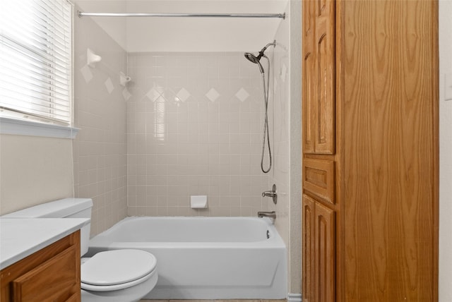 full bathroom featuring vanity, tiled shower / bath combo, and toilet