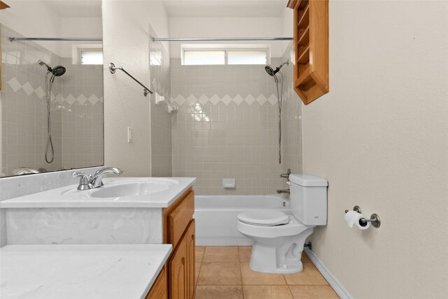 full bathroom with tile patterned floors, tiled shower / bath, vanity, and toilet