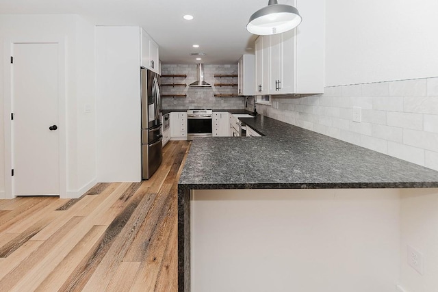 188 W Kaanapali Ln, Bastrop, TX 78602 - kitchen featuring wall chimney exhaust hood, open shelves, dark countertops, appliances with stainless steel finishes, and light wood-style floors