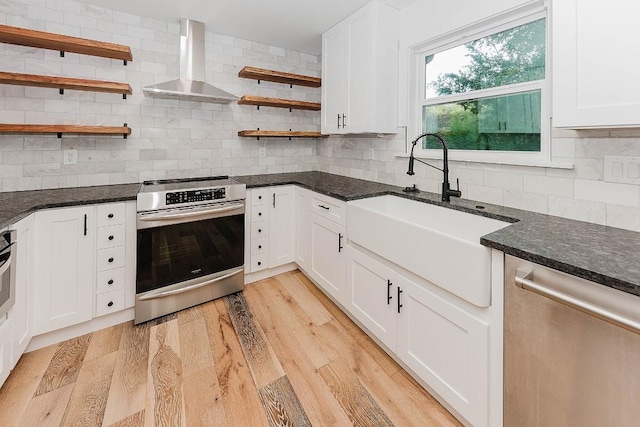 188 W Kaanapali Ln, Bastrop, TX 78602 - kitchen featuring appliances with stainless steel finishes, wall chimney range hood, a sink, open shelves, and tasteful backsplash
