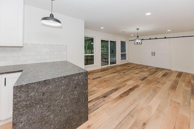 188 W Kaanapali Ln, Bastrop, TX 78602 - kitchen with light wood-style floors, white cabinetry, decorative backsplash, recessed lighting, and pendant lighting