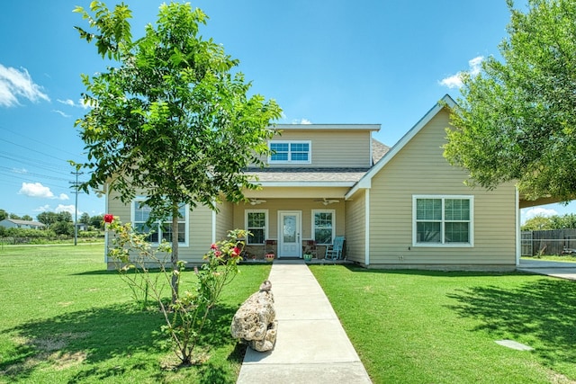 view of front of property featuring a front lawn, covered porch, and a shingled roof