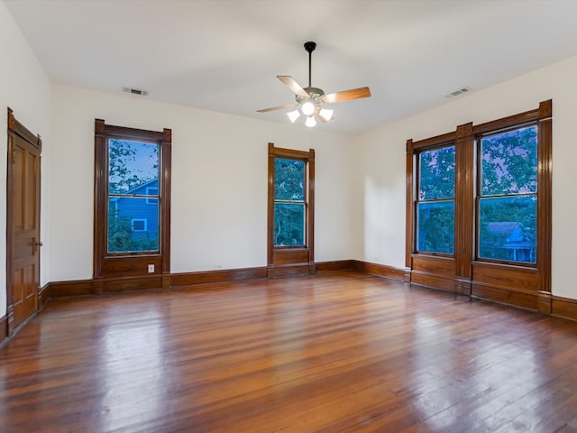 empty room with ceiling fan and dark hardwood / wood-style flooring