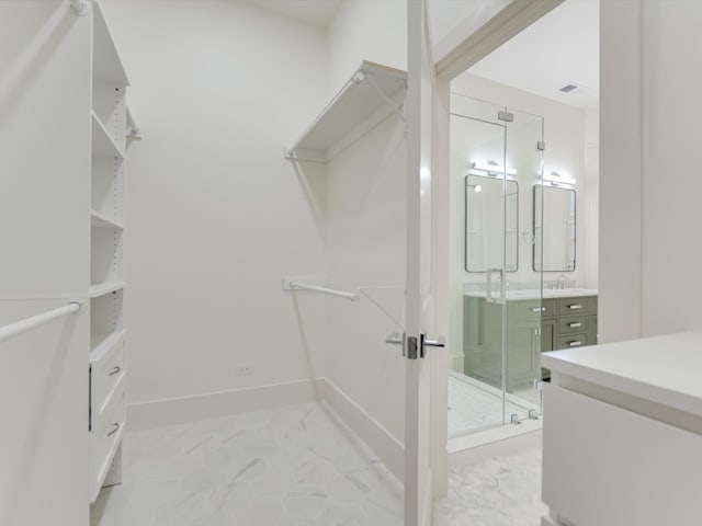 walk in closet featuring sink and light tile patterned floors