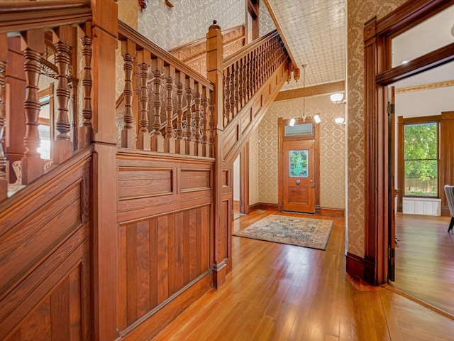 entrance foyer featuring ornamental molding, radiator heating unit, a high ceiling, and wood-type flooring