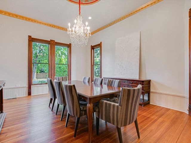 dining area featuring an inviting chandelier, light hardwood / wood-style floors, and ornamental molding