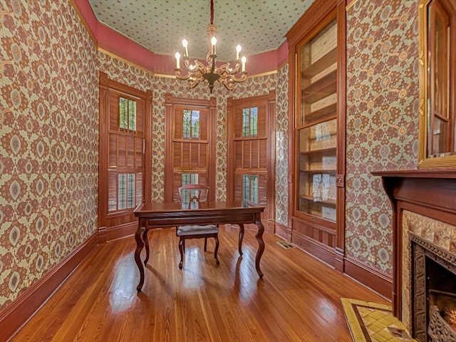 office featuring wood-type flooring, baseboards, a notable chandelier, and wallpapered walls