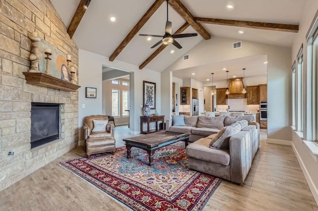 100 Gabgrove Ct, Georgetown, TX 78633 - living area with beamed ceiling, a ceiling fan, light wood-style floors, a fireplace, and high vaulted ceiling