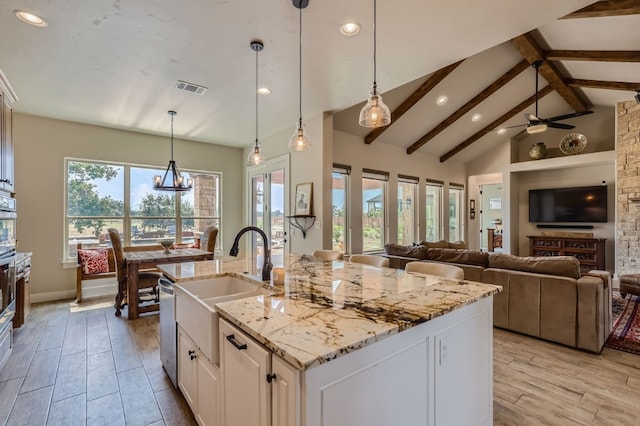 kitchen featuring sink, beamed ceiling, ceiling fan, hanging light fixtures, and white cabinets