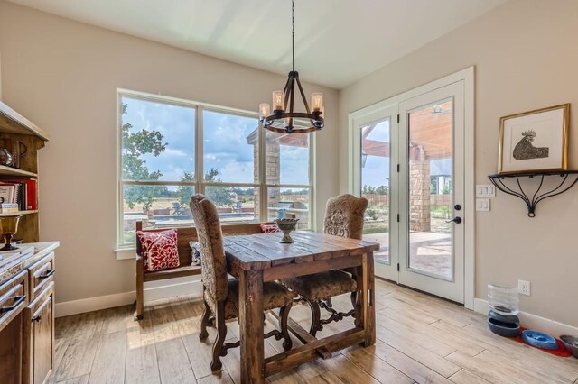 dining area featuring a wealth of natural light, an inviting chandelier, and light hardwood / wood-style floors