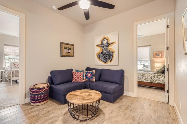 carpeted living room with ceiling fan