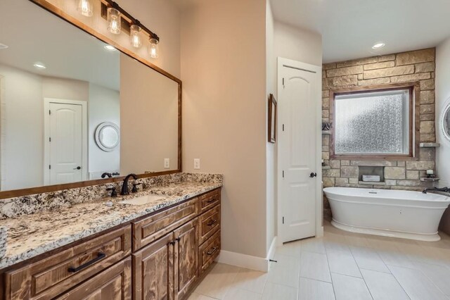 bathroom featuring a bathtub, tile patterned flooring, and vanity