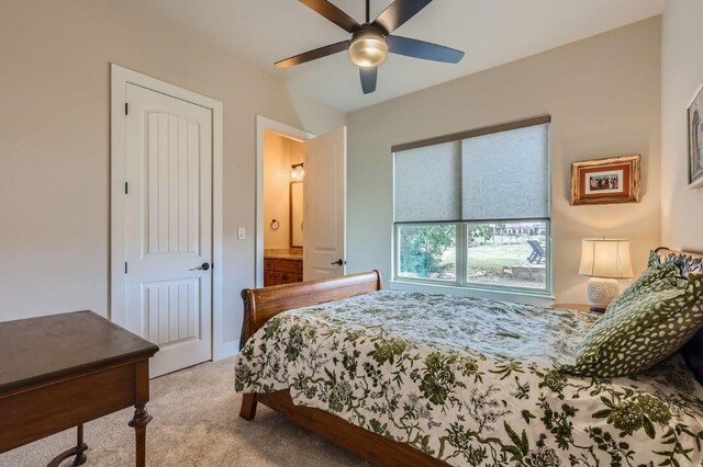 bedroom featuring ceiling fan, light colored carpet, and ensuite bathroom