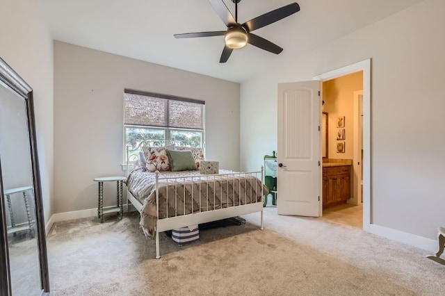 bedroom with ceiling fan, connected bathroom, and light colored carpet