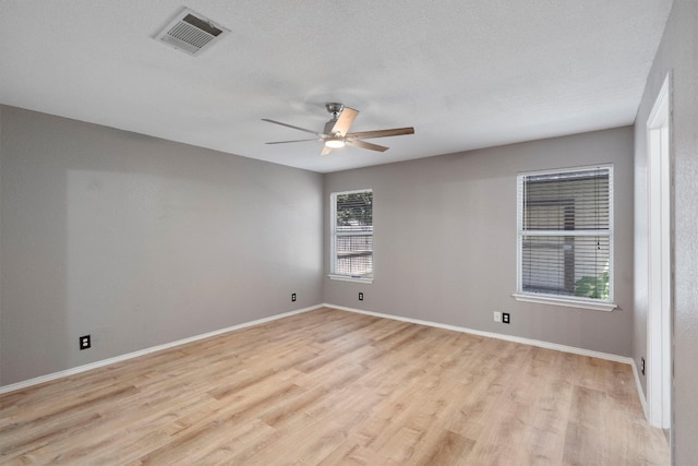 unfurnished room with ceiling fan, light hardwood / wood-style flooring, and a textured ceiling