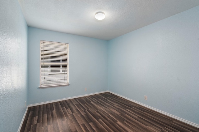 unfurnished room with a textured ceiling and wood-type flooring