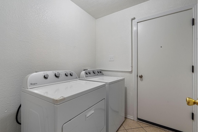 laundry room with a textured ceiling, independent washer and dryer, and light tile patterned floors