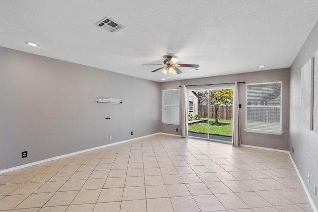 tiled spare room featuring ceiling fan and a textured ceiling