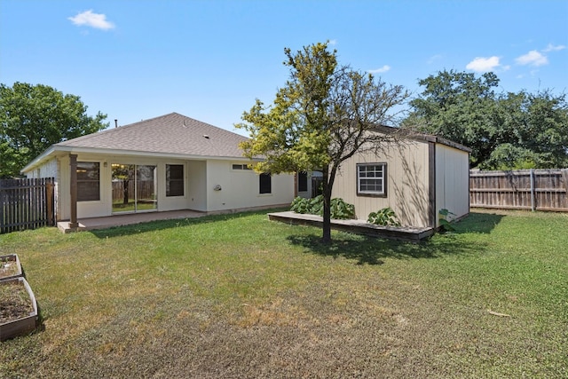 rear view of property with a lawn, a patio area, and a shed