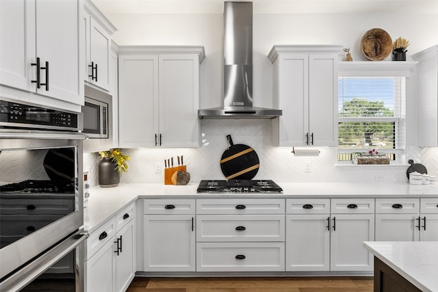 kitchen with decorative backsplash, double wall oven, ventilation hood, wood-type flooring, and white cabinets