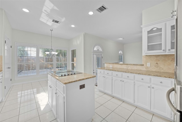 kitchen with light tile patterned flooring, pendant lighting, white cabinets, and backsplash