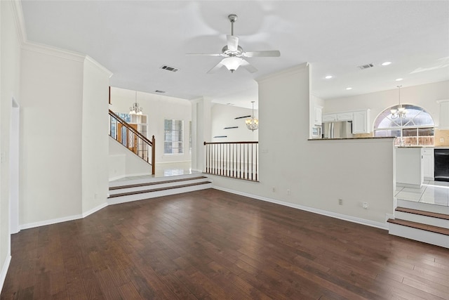 unfurnished living room with dark wood-type flooring, plenty of natural light, and ceiling fan with notable chandelier