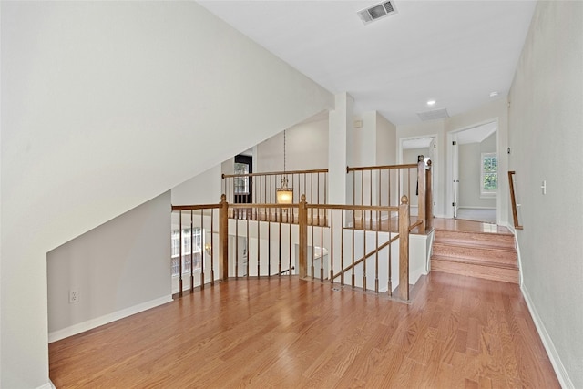 hallway featuring lofted ceiling and light wood-type flooring