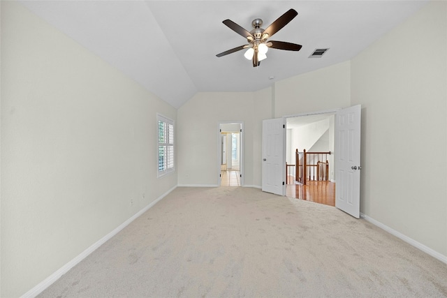 unfurnished bedroom featuring lofted ceiling, light colored carpet, and ceiling fan