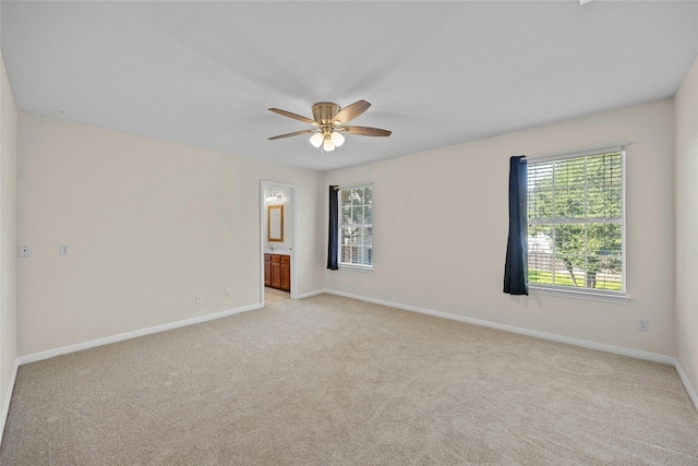 spare room featuring light colored carpet and ceiling fan