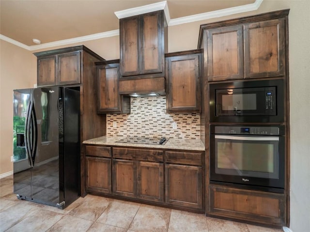 kitchen with light stone counters, dark brown cabinetry, tasteful backsplash, and black appliances