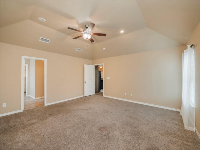 empty room featuring light carpet, vaulted ceiling, and ceiling fan