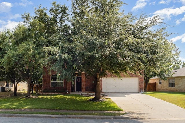 view of property hidden behind natural elements featuring a garage and a front lawn