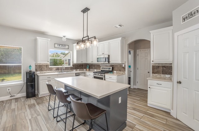 kitchen with white cabinetry, appliances with stainless steel finishes, and backsplash