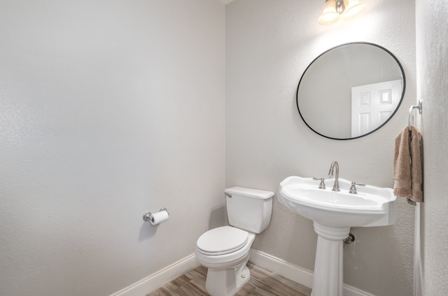 bathroom featuring toilet and wood-type flooring