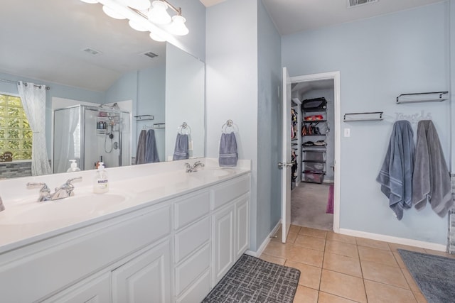 bathroom featuring walk in shower, double vanity, tile patterned flooring, and lofted ceiling